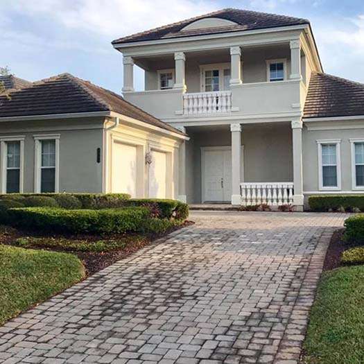 Stained clay tile roof and brick driveway before soft washing